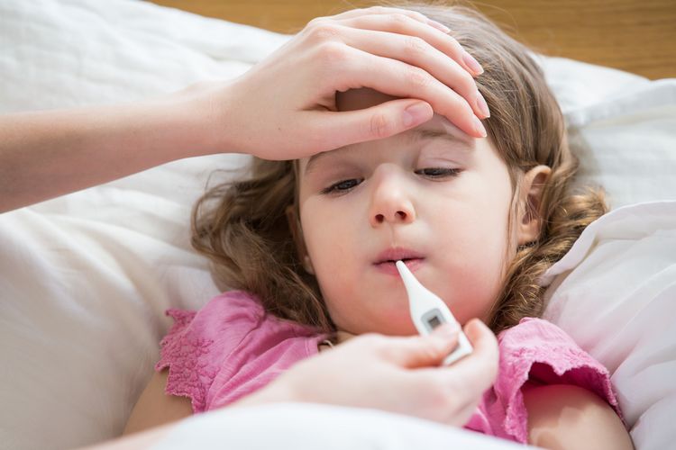 Bei einem erkälteten Kind wird Fieber gemessen.